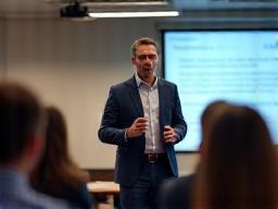 A speaker presenting to a group, representing delivery of training.